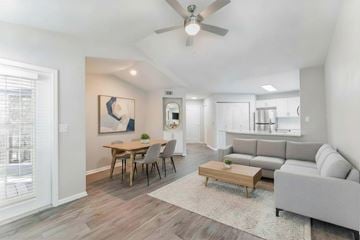 Orlando apartment for rent - A living room with a grey couch, a wooden coffee table, and a painting on the wall.