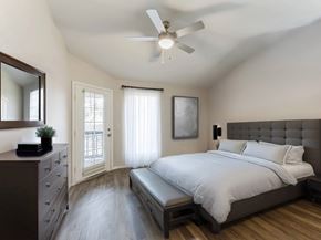 Orlando apartment for rent - A bedroom with a bed, dresser, mirror, and window.