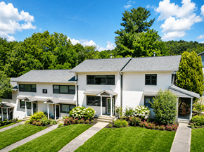 Asheville apartment for rent - A white house with a grey roof and a green lawn in front.