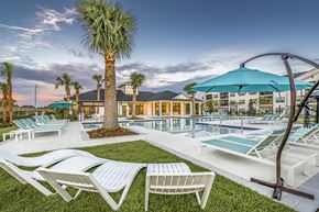 Gainesville apartment for rent - a swimming pool with lounge chairs and umbrellas at the resort