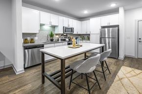 Gainesville apartment for rent - a kitchen with stainless steel appliances and a table with two chairs