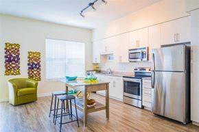 Baltimore apartment for rent - A kitchen with a table and chairs and a refrigerator.