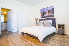Baltimore apartment for rent - A bedroom with a large bed and a painting on the wall.