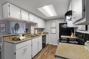 San Antonio apartment for rent - a kitchen with white cabinets and a black stove