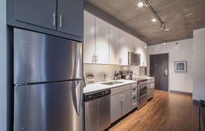 Chicago apartment for rent - A modern kitchen with a stainless steel refrigerator and wooden floors.