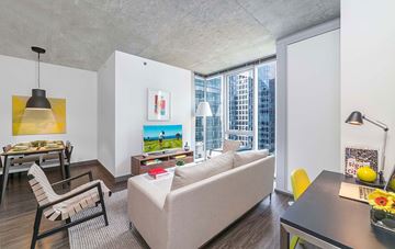 Chicago apartment for rent - A living room with a couch, chair, and a table with a vase of flowers on it.