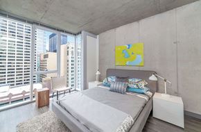 Chicago apartment for rent - A bedroom with a large bed and a city view.