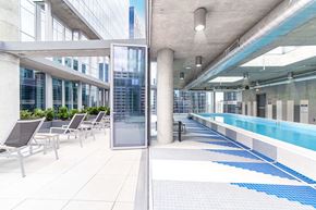 Chicago apartment for rent - A pool area with lounge chairs and a glass wall.