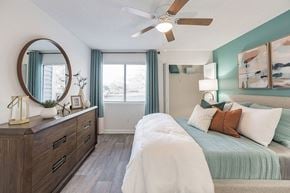 Tampa apartment for rent - A bedroom with a bed, dresser, and mirror.