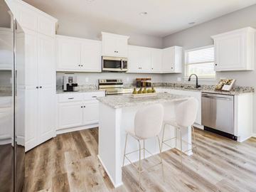 Pleasant Hill apartment for rent - A kitchen with white cabinets and a marble island.