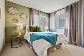 Aurora apartment for rent - a bedroom with green walls and a white bed