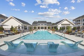Hoschton apartment for rent - a swimming pool with chairs and a house in the background