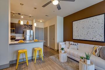 Grand Prairie apartment for rent - A kitchen with a bar and a couch in the living room.