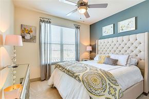 Grand Prairie apartment for rent - A bedroom with a large bed and a ceiling fan.
