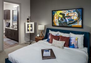 Dallas apartment for rent - a bedroom with a large bed and a painting on the wall