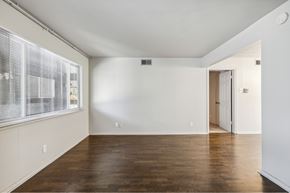 Dallas apartment for rent - an empty living room with white walls and a large window