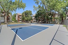 Mission apartment for rent - A tennis court surrounded by trees and buildings.