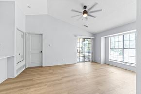 Mission apartment for rent - A spacious room with a ceiling fan and wooden flooring.