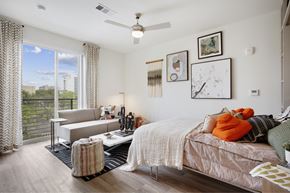 Austin apartment for rent - a bedroom with a bed and a couch and a window