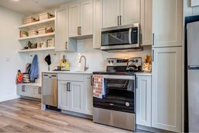 Austin apartment for rent - a kitchen with white cabinets and a stove and a microwave
