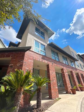 San Antonio apartment for rent - a brick building with palm trees in front of it