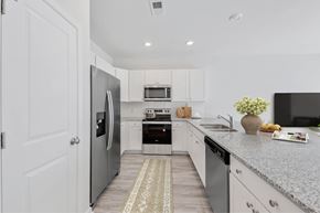 Pooler apartment for rent - a white kitchen with stainless steel appliances and a counter top