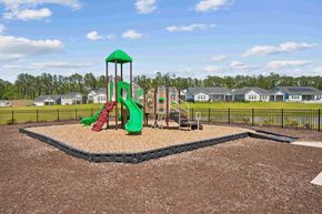 Bluffton apartment for rent - our playground has a variety of play equipment with houses in the background