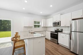 Bluffton apartment for rent - a kitchen with white cabinets and stainless steel appliances