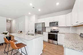 Pooler apartment for rent - a kitchen with white cabinets and a counter top