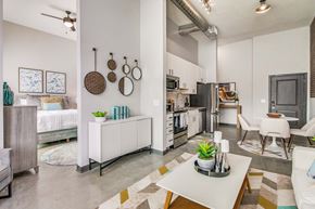 Pensacola apartment for rent - a living room with a table and a kitchen in the background