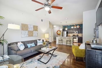 San Antonio apartment for rent - A modern living room with a grey couch and a glass coffee table.