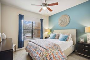 San Antonio apartment for rent - A bedroom with a bed, nightstands, and a ceiling fan.