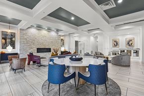 Dallas apartment for rent - A modern dining room with a stone fireplace and a large table surrounded by chairs.