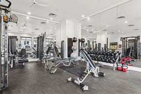 Dallas apartment for rent - A gym with a variety of equipment including weights and machines.