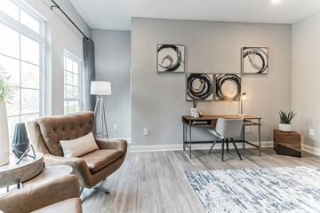 Gainsville apartment for rent - A modern living room with a brown chair and a grey couch.