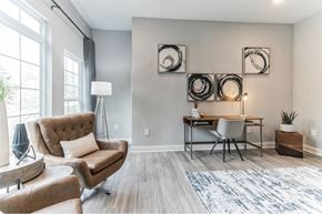Gainesville apartment for rent - a living room with a couch and a desk and a window