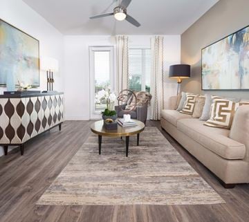 Plano apartment for rent - A living room with a beige sofa, a coffee table, and a painting on the wall.