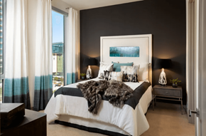 Plano apartment for rent - A bedroom with a large bed and a view of the outside.