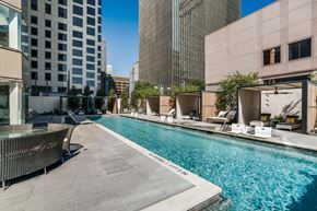 Dallas apartment for rent - A swimming pool with a concrete floor and a concrete wall with a glass window.