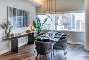 Dallas apartment for rent - A dining room with a table set for a meal and a city view.
