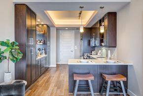 Dallas apartment for rent - A kitchen with dark wood cabinets and a white island.