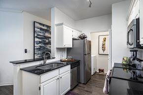 Orlando apartment for rent - A kitchen with a black counter top and white cabinets.