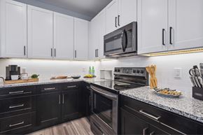 Sanatoga apartment for rent - A kitchen with black and white cabinets and appliances.