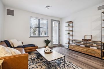 Sanatoga apartment for rent - A living room with a brown couch, a white coffee table, and a rug with a black and white pattern.