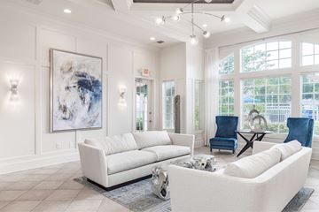 Orlando apartment for rent - A living room with a white couch and a large abstract painting on the wall.