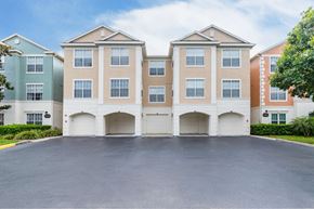 Orlando apartment for rent - A large building with a parking lot in front.