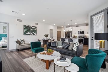 Sanatoga apartment for rent - A modern living room with a dark green chair and a white coffee table.