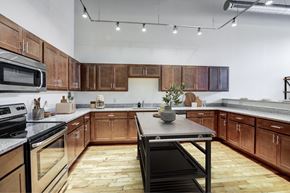 Menands apartment for rent - A kitchen with wooden cabinets and a black stove top oven.