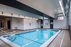 Cohoes apartment for rent - A large indoor swimming pool with a blue tinted water.