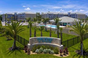Fort Myers apartment for rent - A resort with a pool and palm trees.